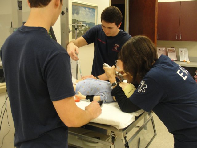 EMS Students clearing air way on infant paitent simulator