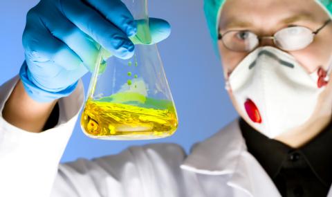 Lab Tech examing contents erlenmeyer flask