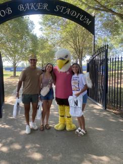 Eagles Mascot with female student and parents at the athletic complex gate