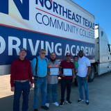 cdl graduates with instructors in front of truck. 