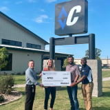 check presentation in front of diamond c sign