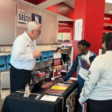 students visit booth at college fair