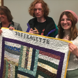 students presenting quilt