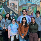 group in front of mural