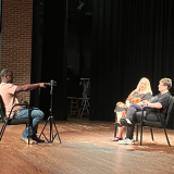 student interviewing people on Whatley stage